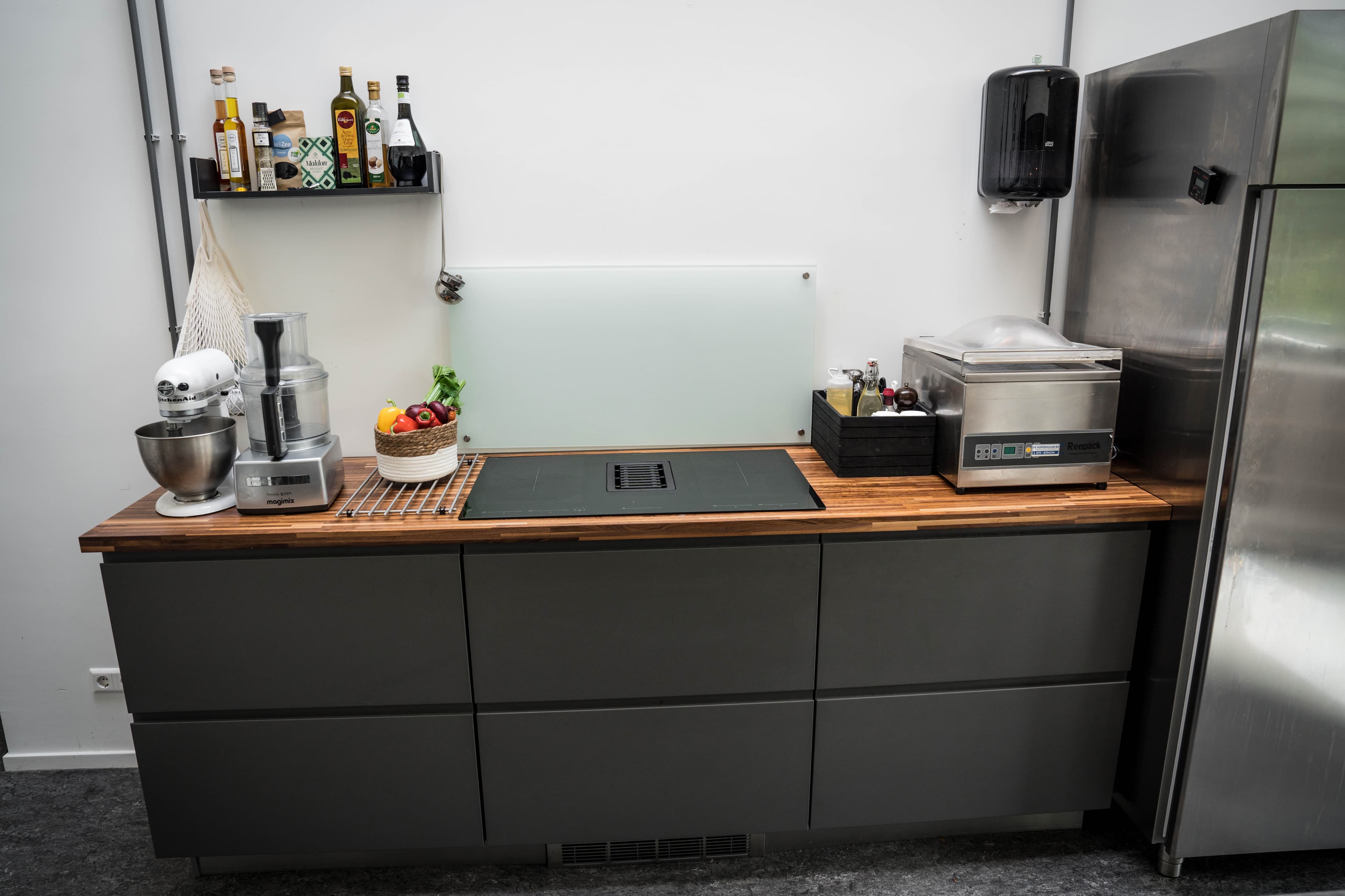 Werkblad met inductiekookplaat, Kitchenaid en vacuümmachine